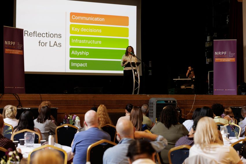 Image showing a speaker in front of a slide setting out what councils can do to address challenges